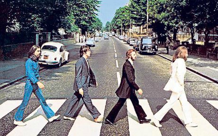 Integrantes dos Beatles atravessando a rua no sentido esquerda para a direita.